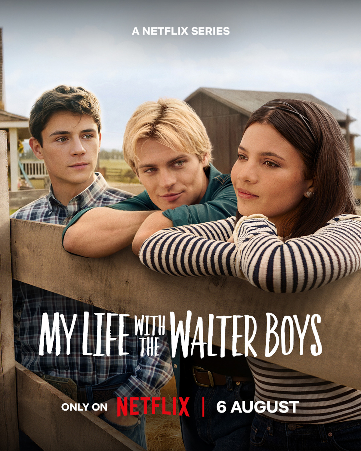 Three teens lean on a wooden fence in a rural farm setting with barns in the background; promotional poster for Netflix series "My Life with the Walter Boys," premiering August 6.