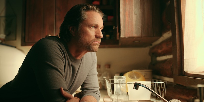 Martin Henderson as Jack Sheridan leans over a kitchen counter looking out the window in Season 5 of ‘Virgin River.’