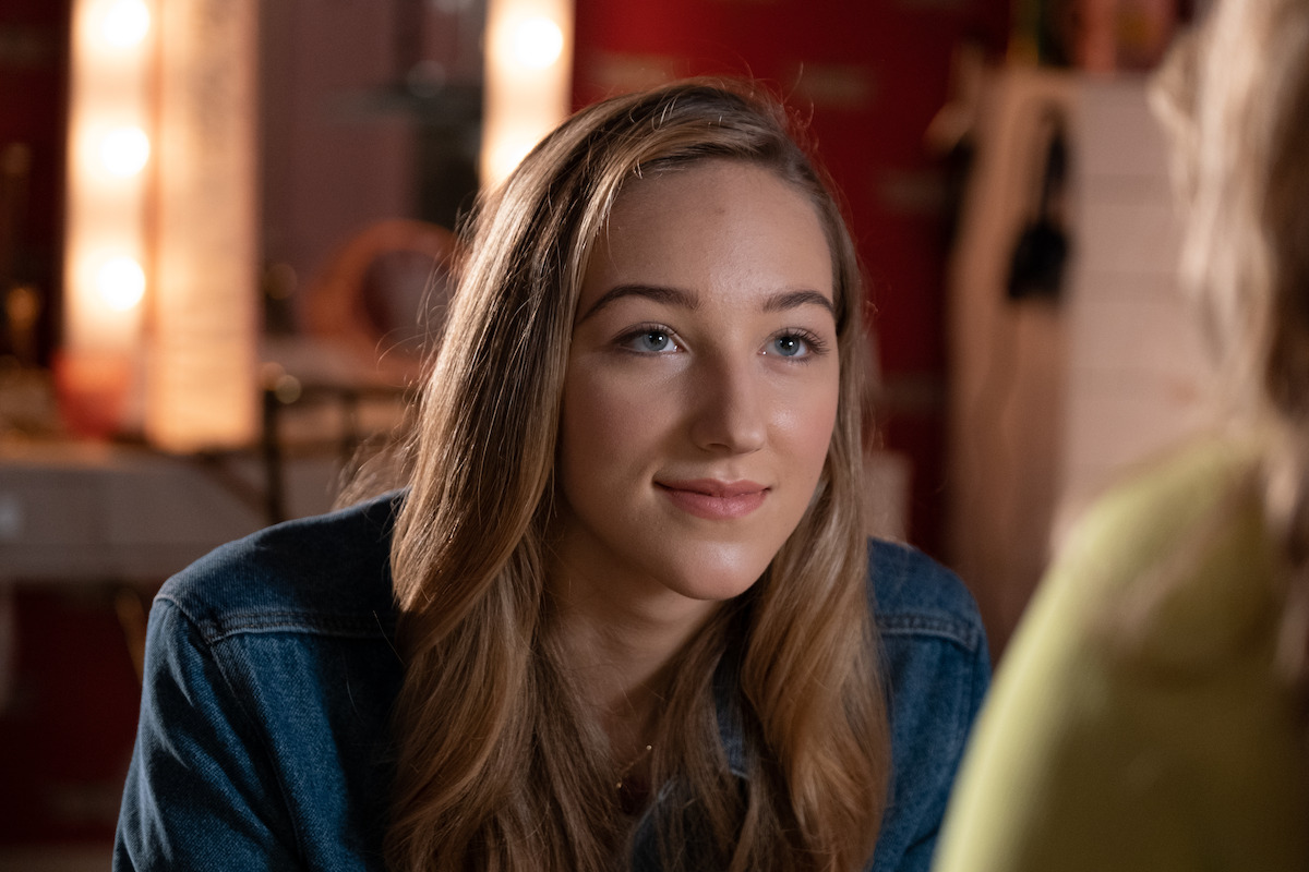 An Evil Look From An Old Grinning Face Sitting Behind A Table