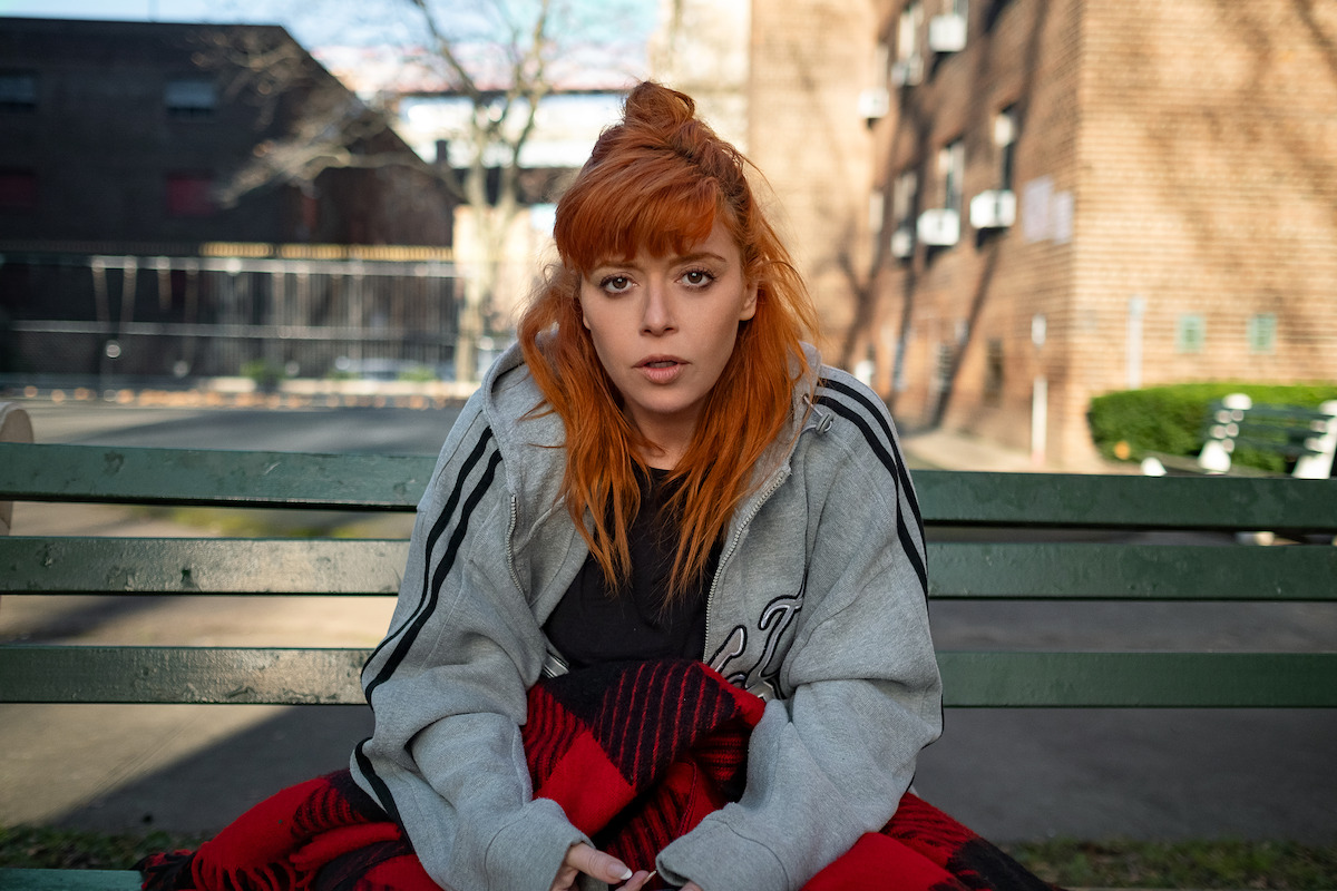 Natasha Lyonne’s character Rachel wears a gray sweatshirt and looks stoned.
