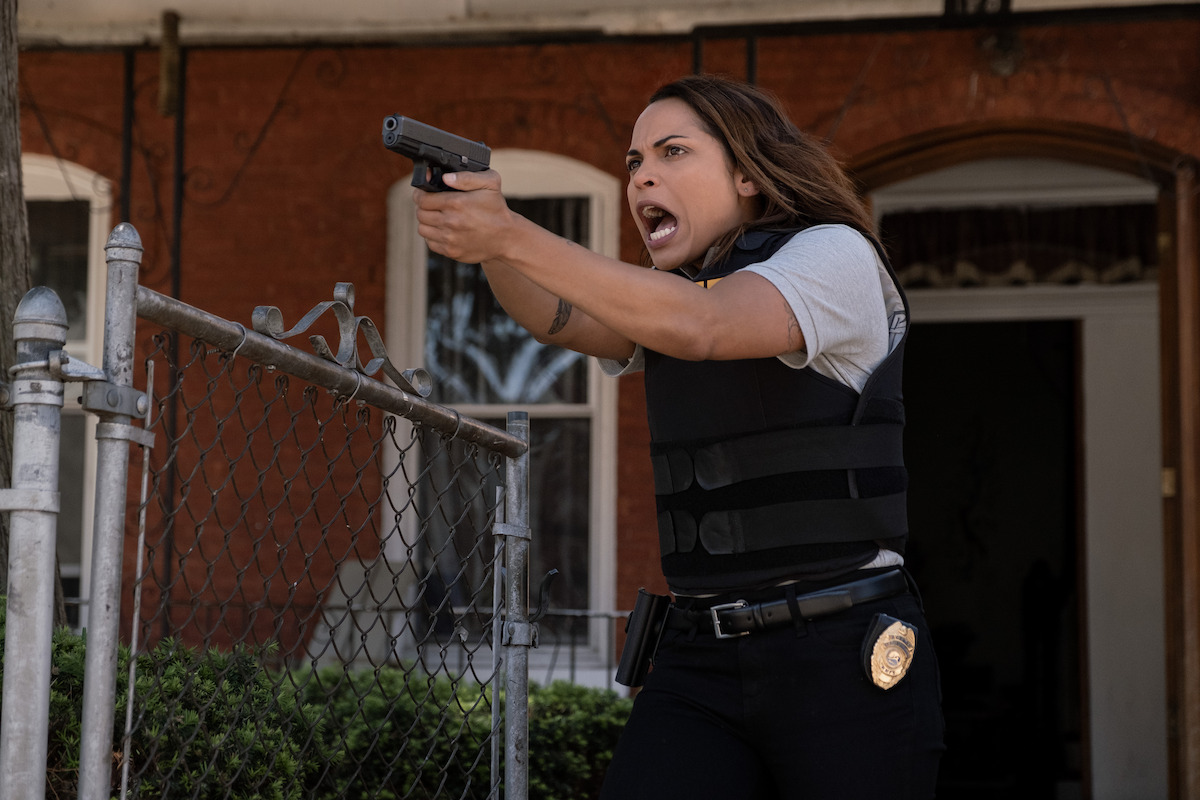 Monica Raymund as Jackie in police uniform holds a gun while yelling in an image from ‘Hightown.’