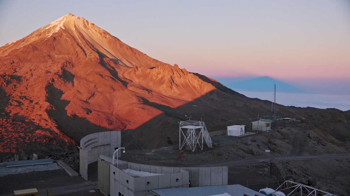 An overhead shot of a mountain with a scientific facility nearby