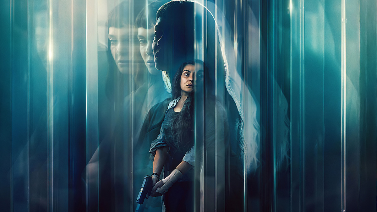 A woman holding a gun stands in a dark, mysterious environment with blue tones and blurred, ghostly reflections of herself and another woman, creating a suspenseful and intense atmosphere.