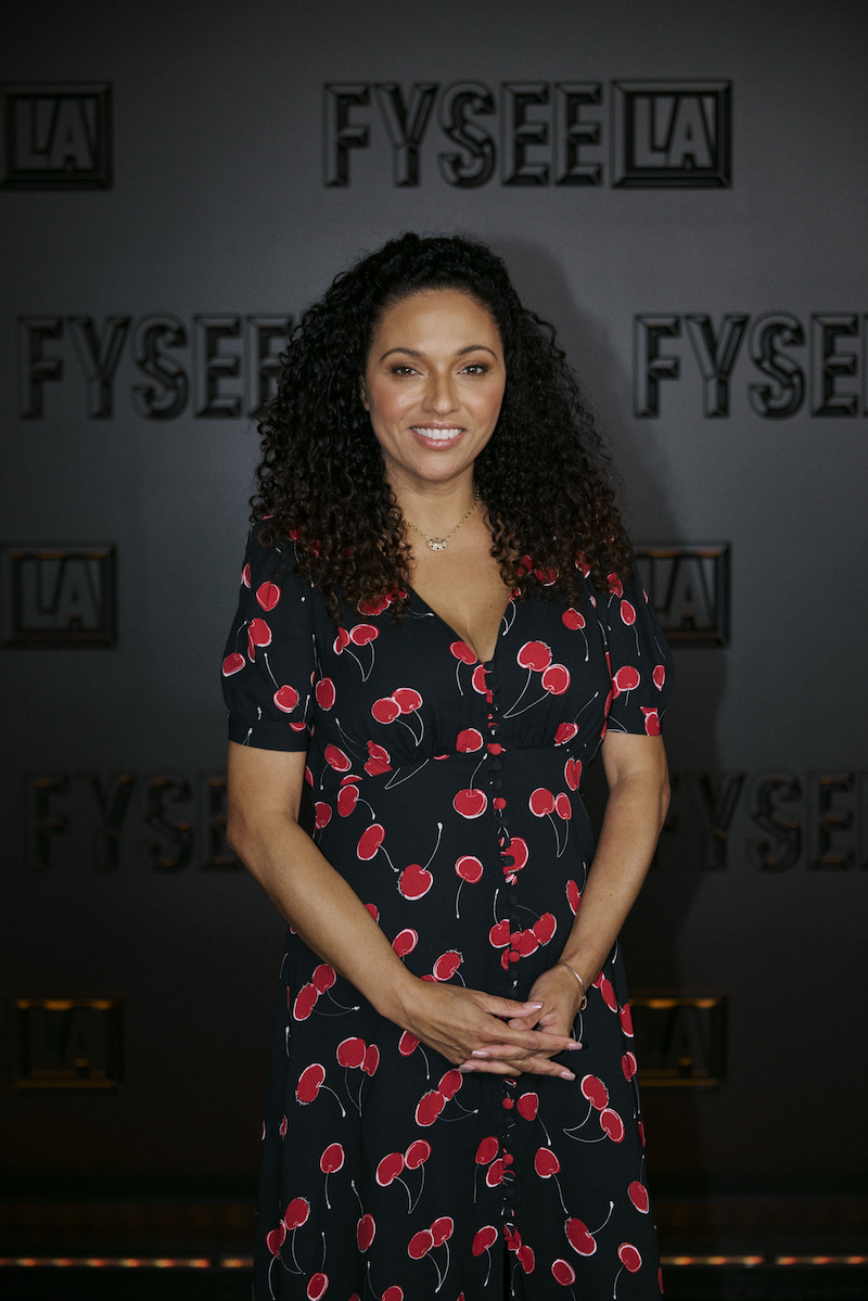 A woman in a floral print dress poses.