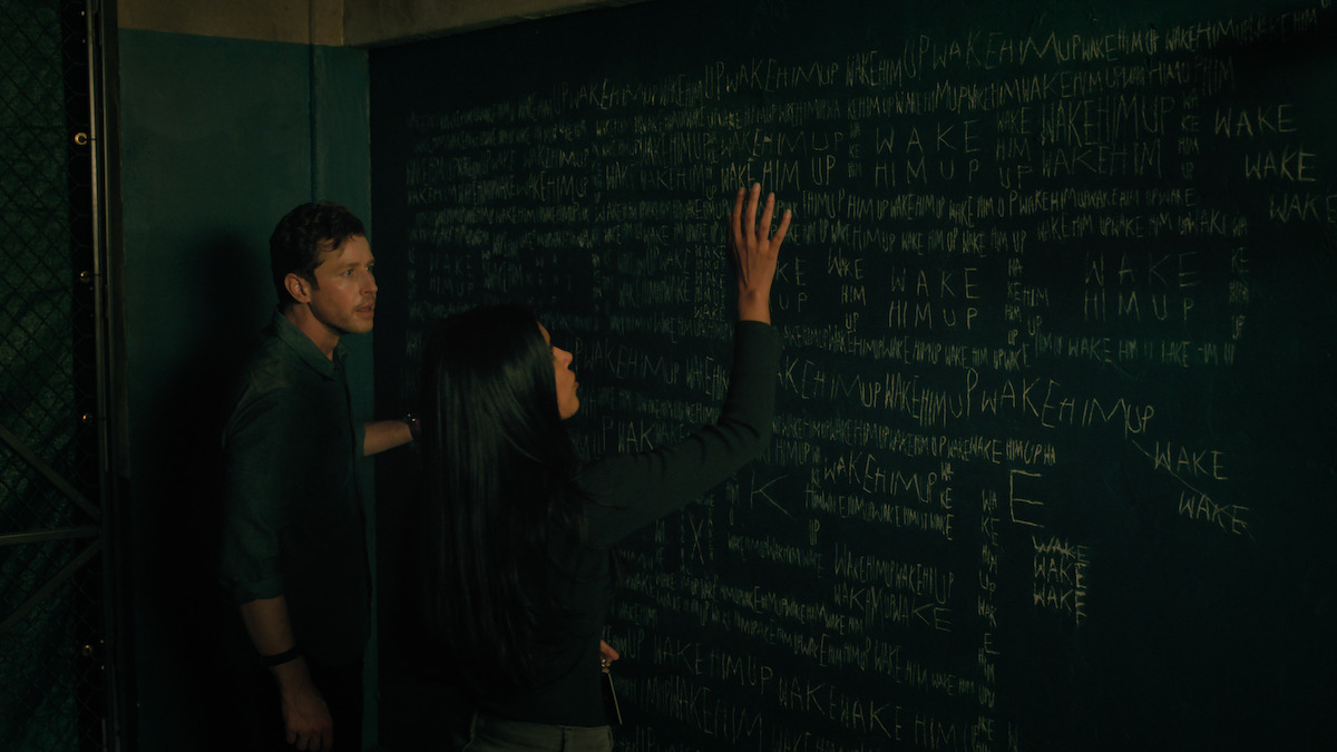 Man and woman in front of chalkboard.