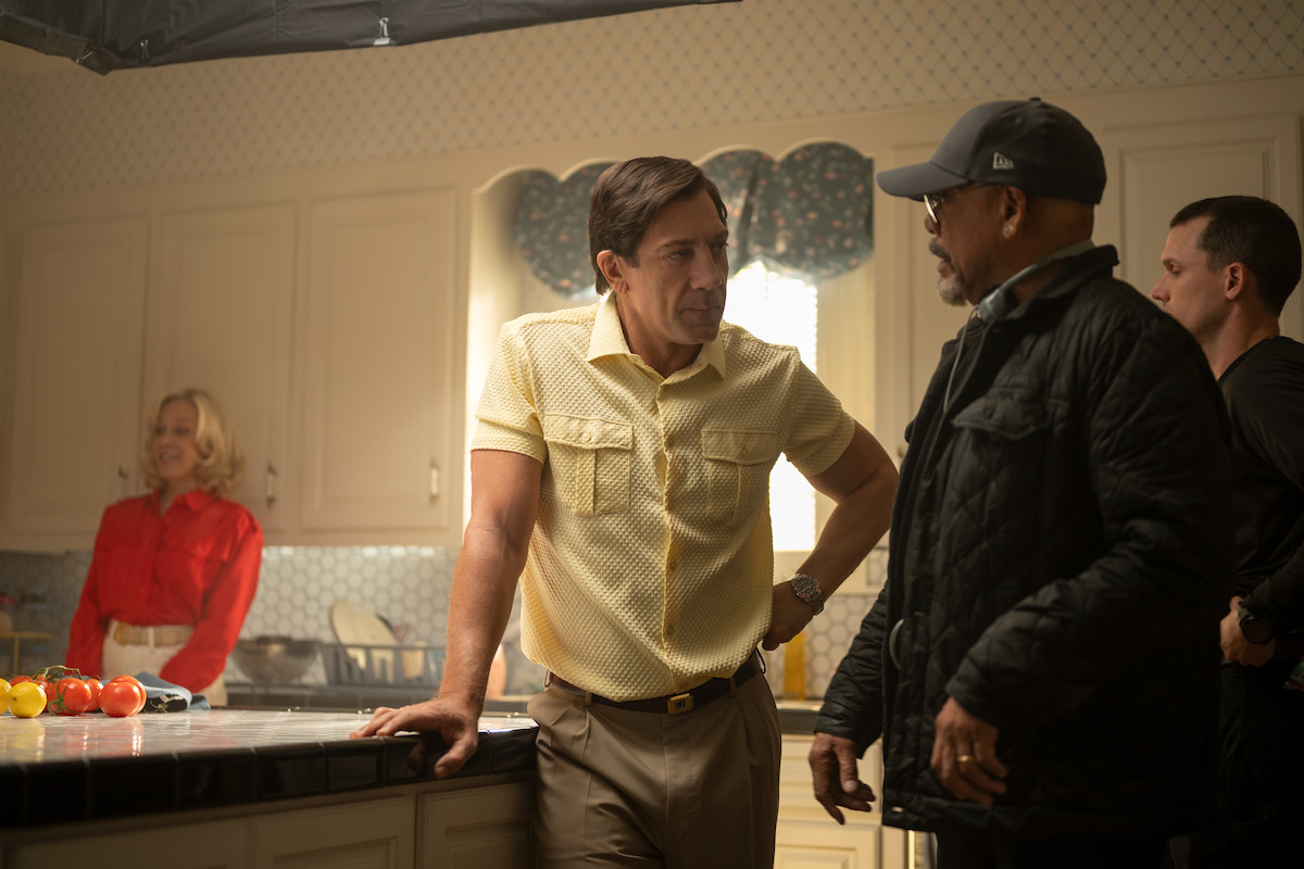 Behind the scenes with Chloë Sevigny and Javier Bardem as Kitty and Jose Menendez.Sevigny wears a red top and Bardem wears a yellow button-down top.