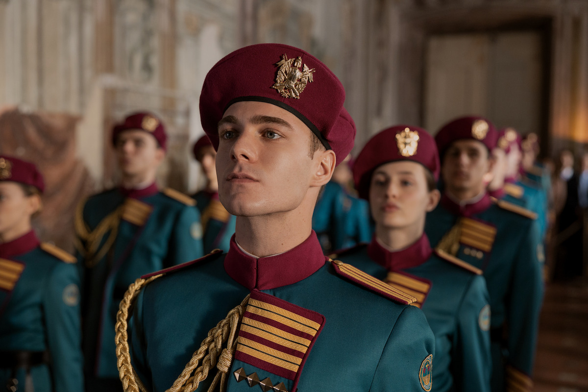 Alunos de uma escola militar formam fila em trajes formais verdes com detalhes em vermelho e dourado