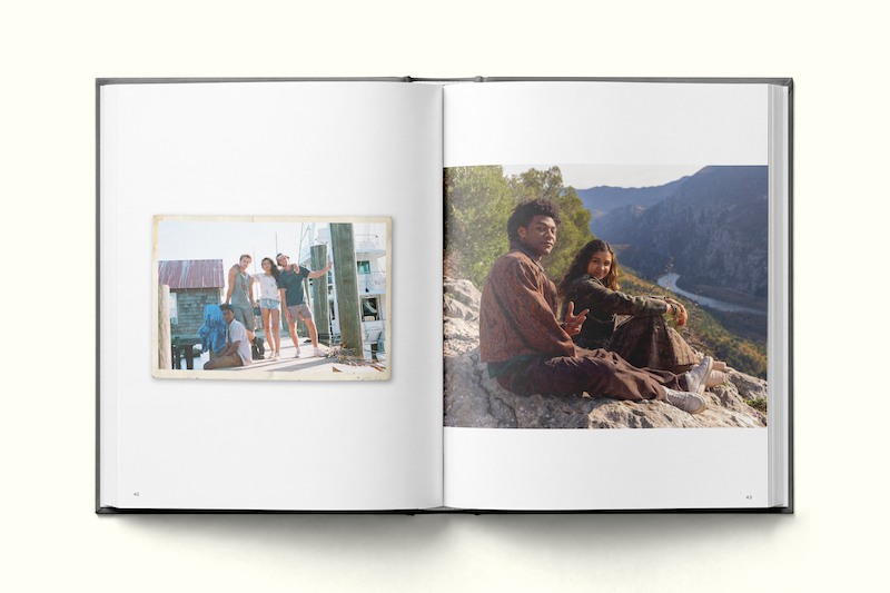 Photo book open to two pages: left side shows a casual vintage photo of people posing outdoors near a building, right side features two people sitting on a rock with a scenic river and mountain landscape in the background.