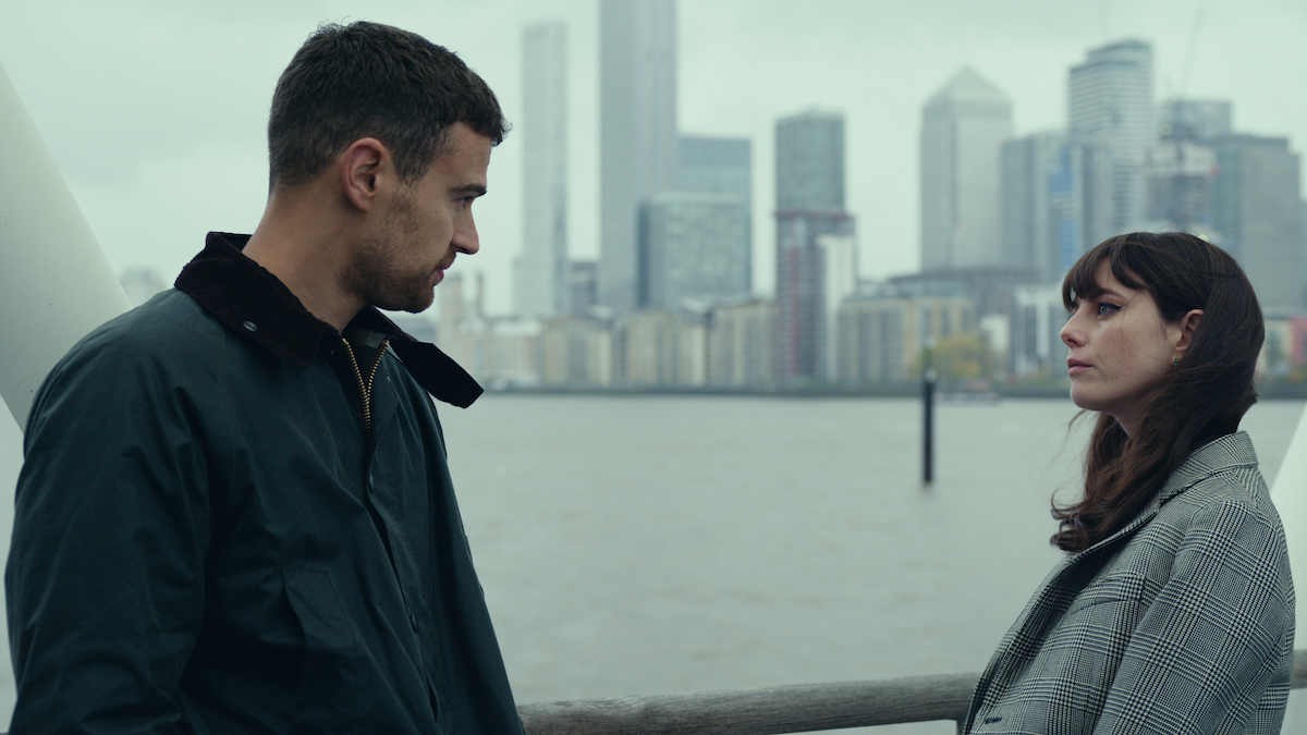 Theo James as Eddie Horniman and Kaya Scodelario as Susie Glass face each other near a river in Season 1 of ‘The Gentlemen.’
