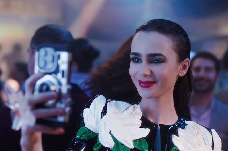 Lily Collins as Emily takes a photo in Season 4 of 'Emily in Paris'