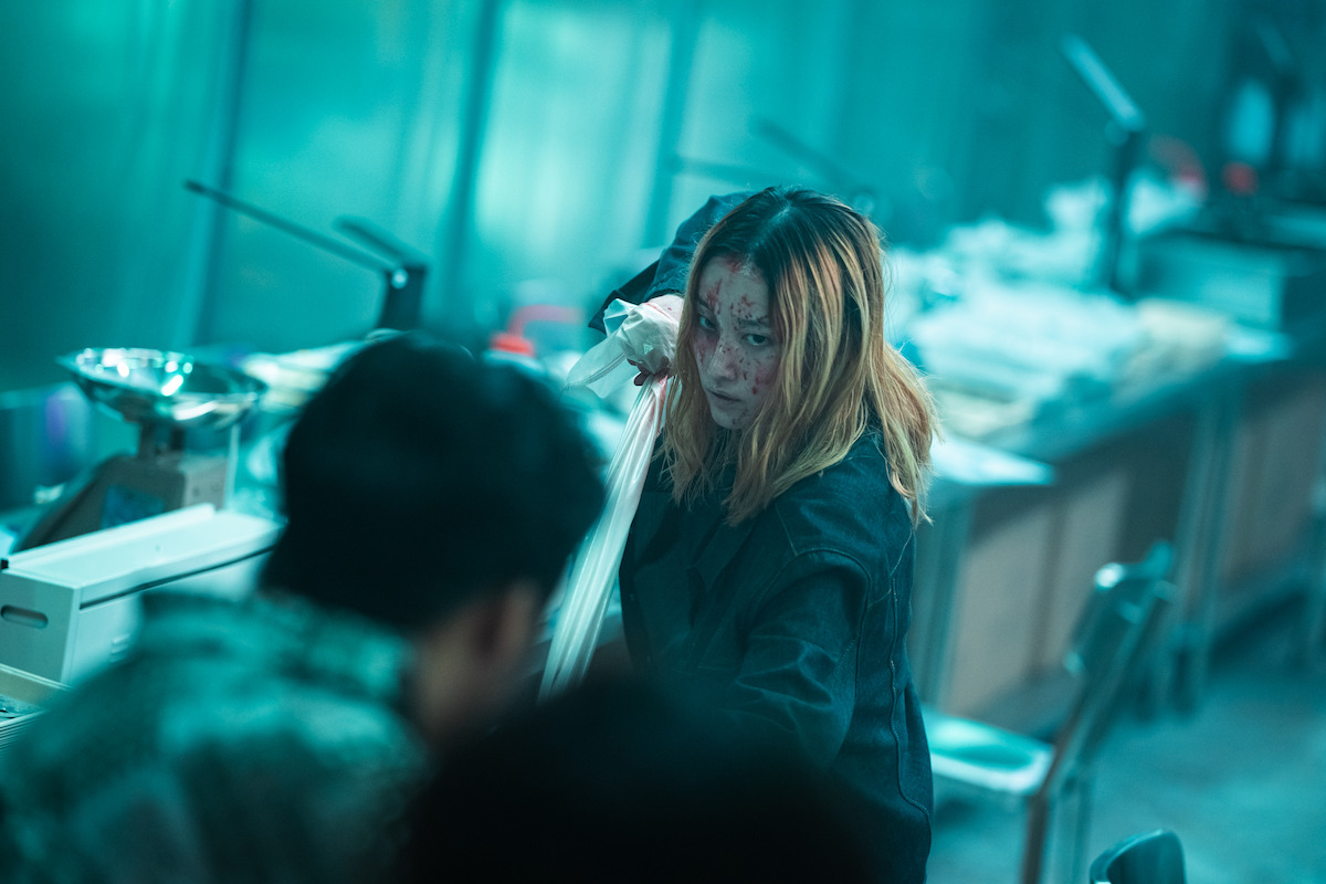 Jun Jong-seo as Ok-ju, covered in blood with her fist raised, prepared to fight
