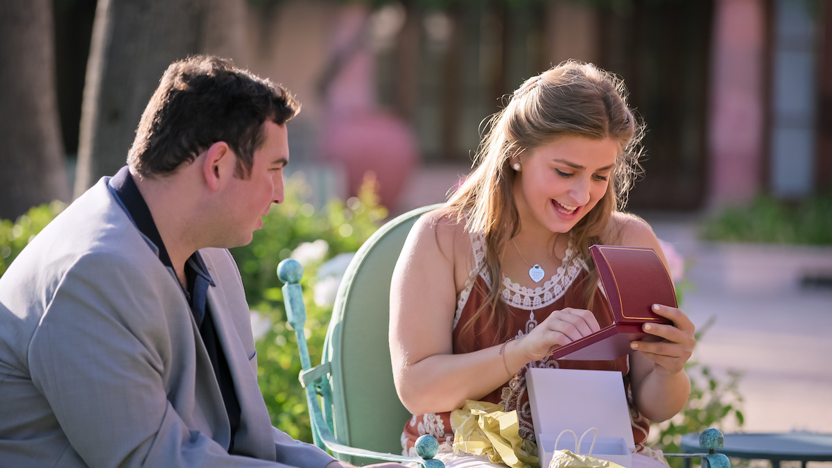 Abbey opens presents as David looks on.