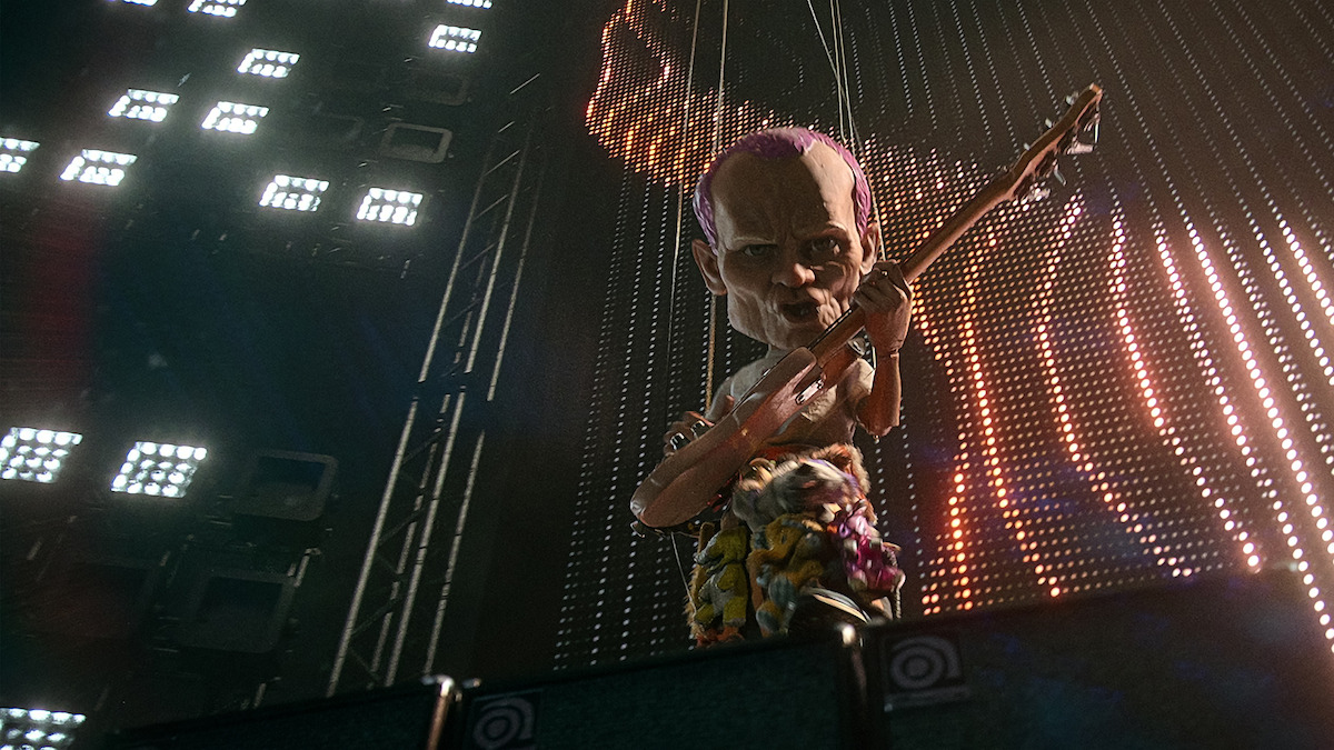 A puppet doll-like version of Flea playing his bass onstage.