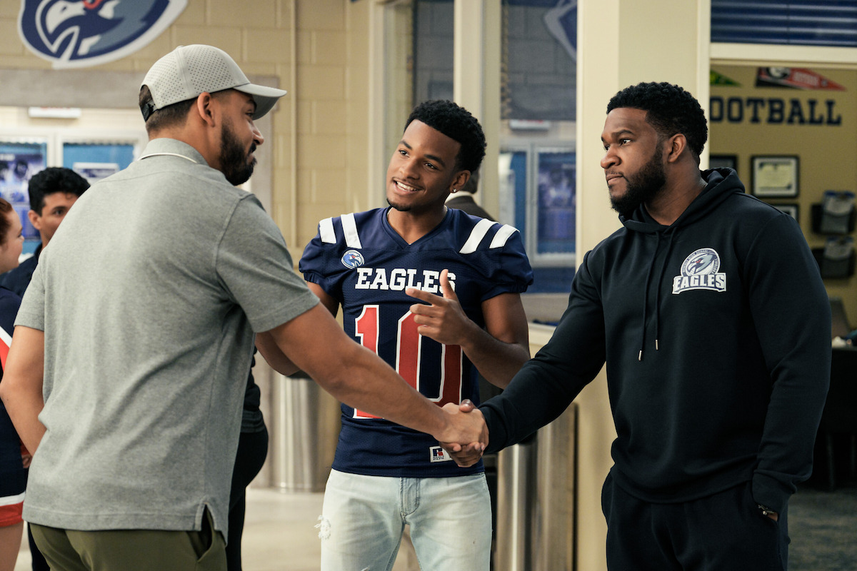 Two people shake hands in an image from ‘All American.’
