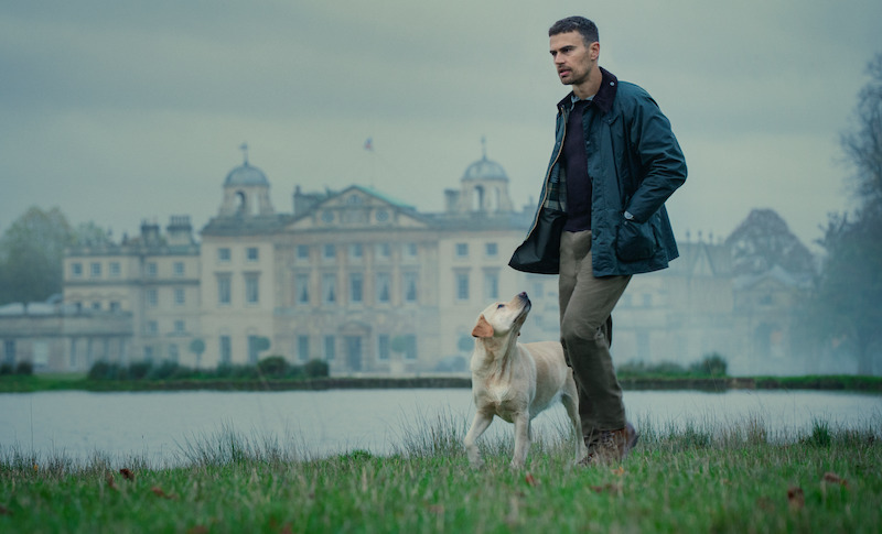 James as Eddie Horniman walks a dog in front of a grand estate in Season 1 of ‘The Gentlemen.’