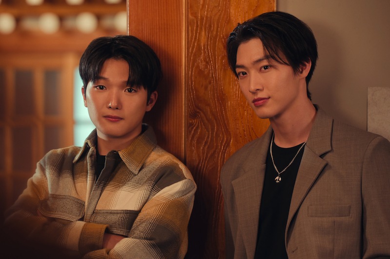 Minyeong Choi as Dae Heon Kim and Sang Heon Lee as Min Ho Moon lean against a wall in Season 2 of 'XO, Kitty'