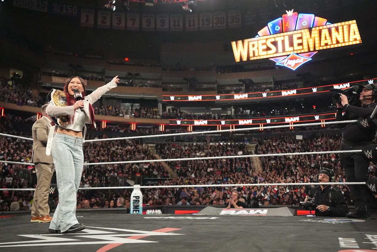 What Time Does Wrestlemania 41 Start? Schedule, Location & News Rehmat Boutique Iyo Sky points at a WrestleMania sign.