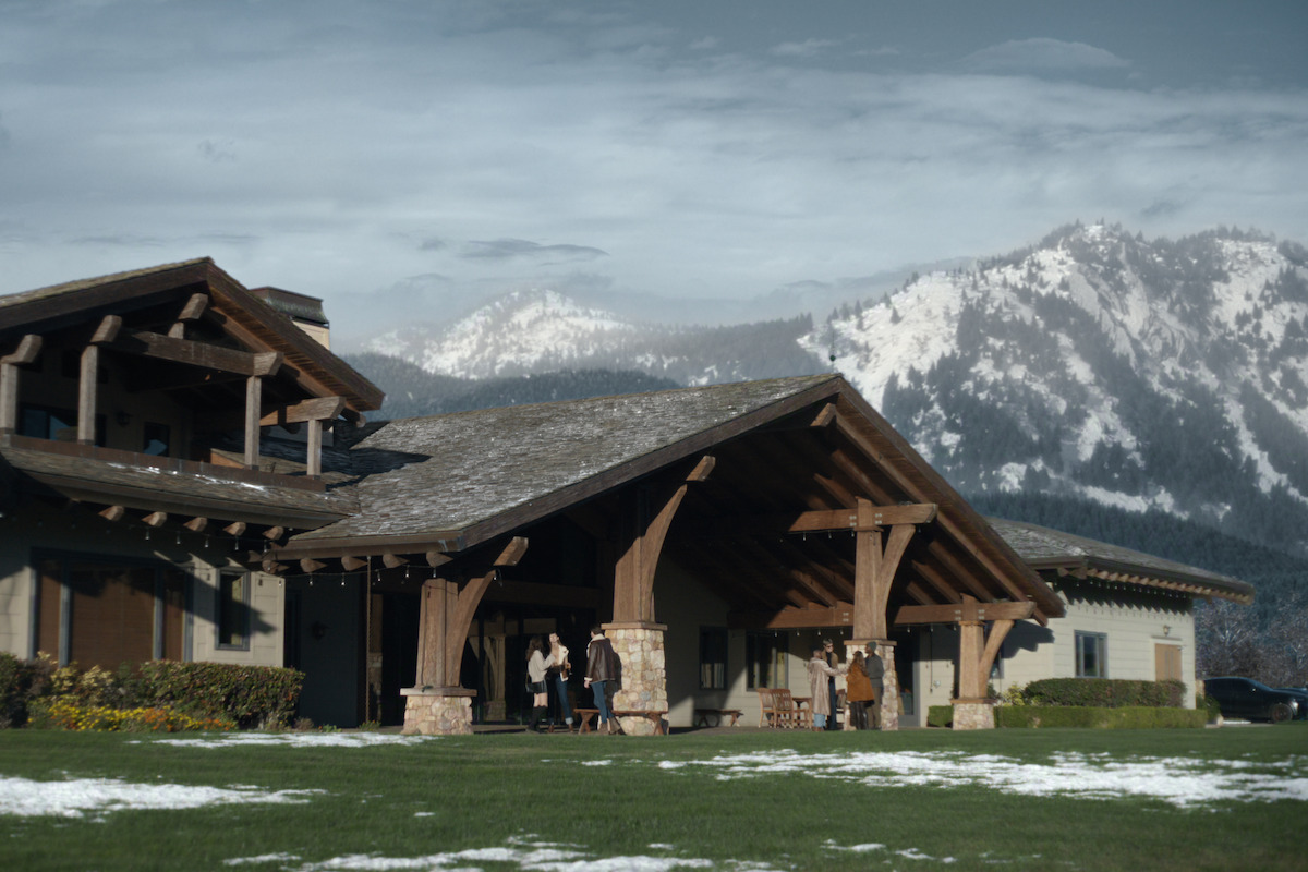 Band performing on stage with colorful neon lights in the background, musicians playing instruments and singing, audience watching and enjoying the live outdoor concert at night.