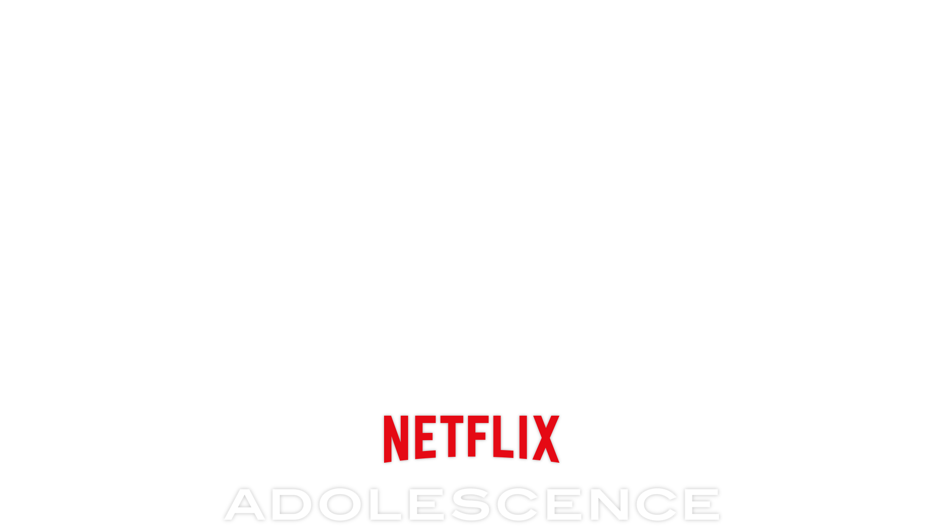 Adolescence key art - A man in an orange shirt is looking down on a teenager who looks despondent while sitting on the edge of his bed. 