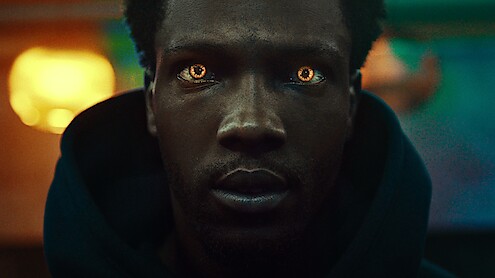 Close up shot of a man with glowing golden eyes in Season 1 of 'Supacell'