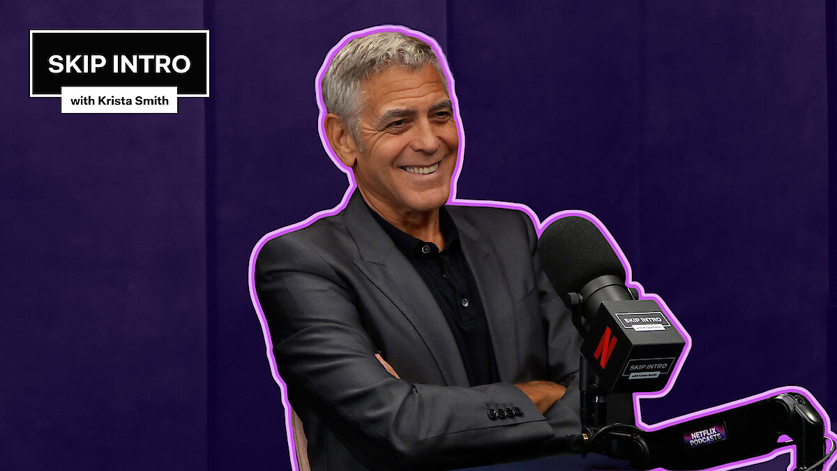 George Clooney sits smiling in front of a microphone during a podcast recording for "Skip Intro with Krista Smith." The background is purple, and the podcast logo appears in the top left corner.