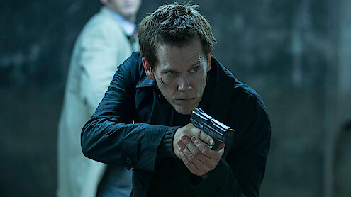 Kevin Bacon as Special Agent Ryan Hardy points a gun at a suspect in 'The Following.'