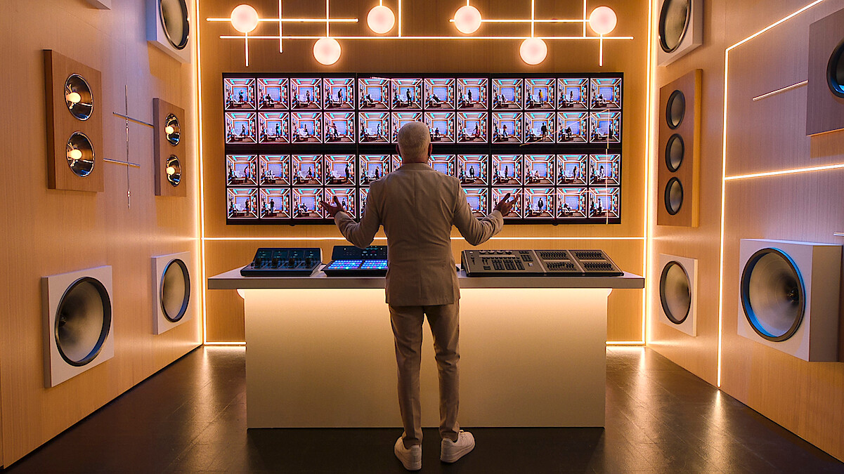 AJ McLean stands in front of a screen featuring the 'Building the Band' Season 1 booths.