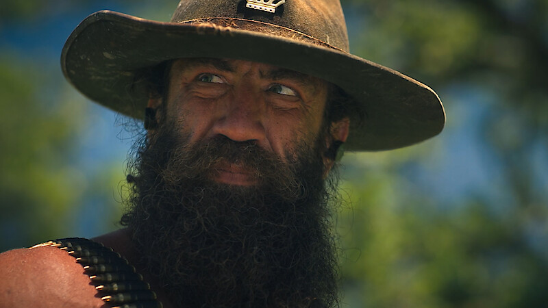 "Live King" Brian Johnson wearing a hat with a bullet belt over his shoulder.