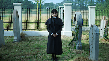 Jenna Ortega as Wednesday Addams stands in a graveyard in 'Wednesday' Season 2.