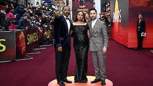 A trio stands on the red carpet. 