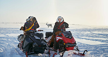 Lars-Ante Wasara as Mattias and Elin Oskal as Elsa sit on snowmobiles in 'Stolen.'
