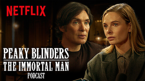 Two serious people sit indoors, warmly lit, in a conversation setting. The Netflix logo and "Peaky Blinders: The Immortal Man Podcast" text is displayed prominently in white across the image.