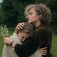 Two women hugging in a field