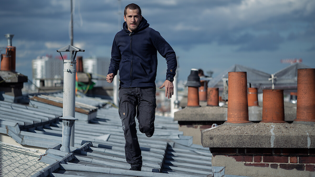 Guillaume Canet runs on a rooftop in the film 'Ad Vitam.'