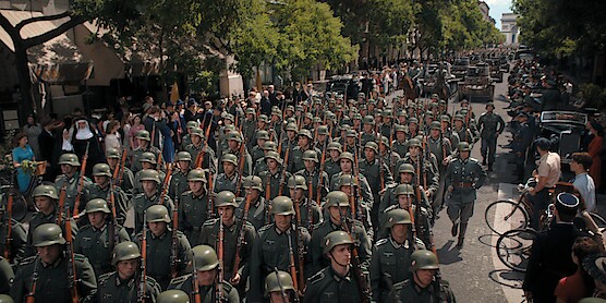 A street filled with columns of soldiers marching. 