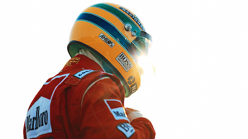 Ayrton Senna (Gabriel Leone) wears a red Marlboro jacket and a green-and-yellow helmet as he gears up to race.