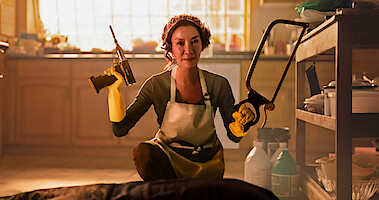 Michelle Yeoh as Eileen Sun holds a drill and saw in a kitchen while wearing a hairnet in Season 1 of 'The Brothers Sun'
