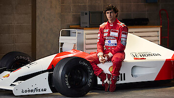 Gabriel Leone as Ayrton Senna sits on the side of his race car in 'Senna'
