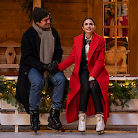 Lucas Bravo as Gabriel and Lily Collins as Emily sit at an ice skating rink in Season 4, Part 2 of 'Emily in Paris' 