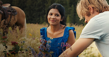 Nikki Rodriguez as Jackie Howard sits in a field of flowers in Season 1 of 'My Life with the Walter Boys'