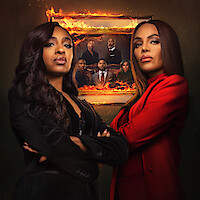 Two women stand confidently in front of a burning family portrait, wearing dark and red suits in a dramatic setting, with intense expressions and crossed arms, suggesting tension and conflict.