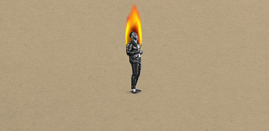 Kevin Hart in black-and-white stands on a tan background, with their head replaced by a large bright flame, suggesting a surreal or artistic concept.