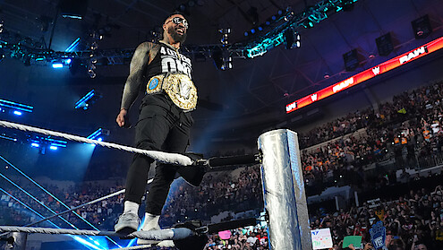 Jey Uso standing on a rope with his belt on facing the crowd.
