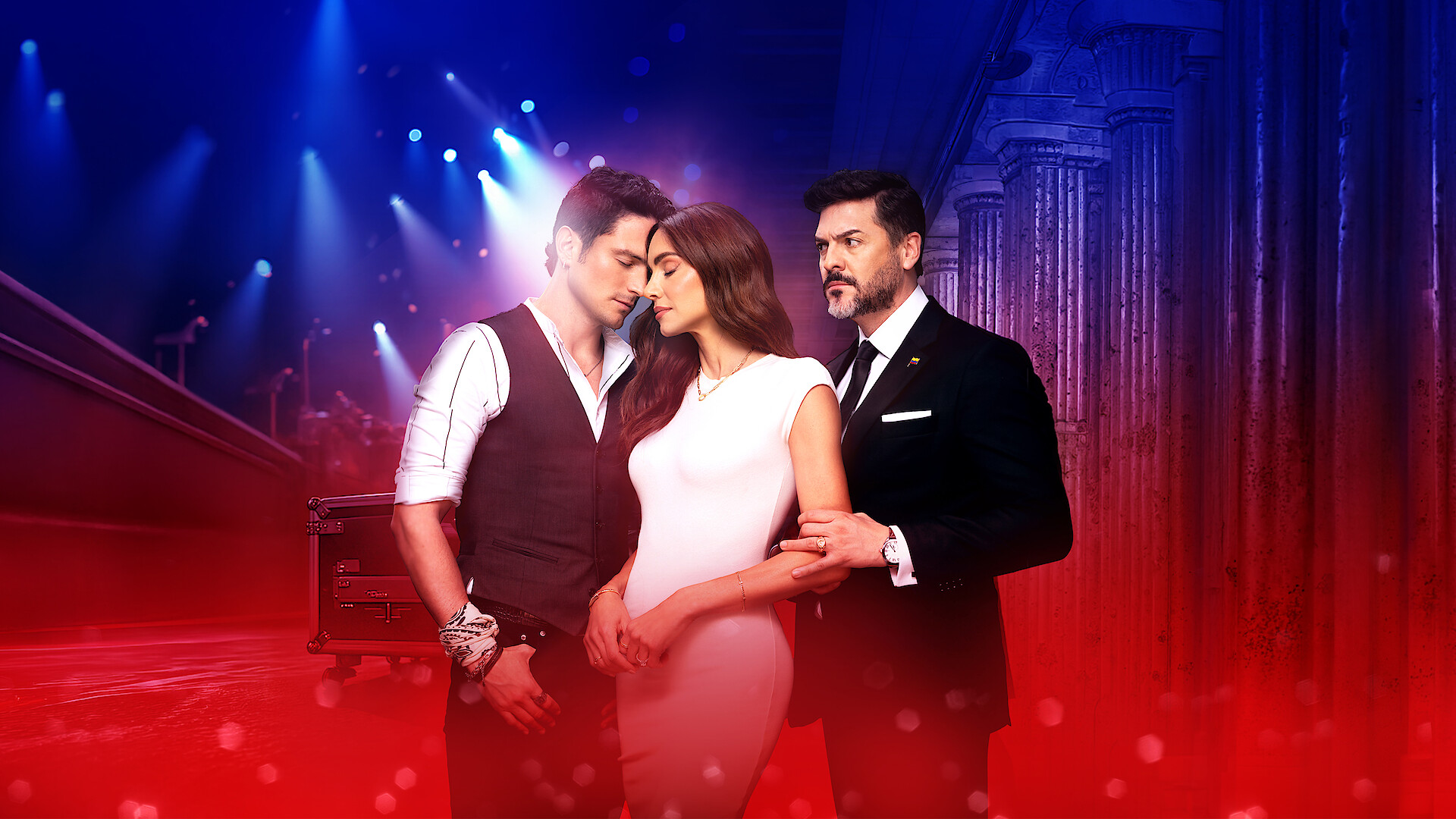Three well-dressed people stand closely together in a dramatic, glamorous setting with blue stage lights and architectural columns, suggesting a romantic or intense relationship dynamic.