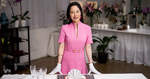 Woman in pink dress standing over counter