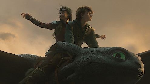 Mason Thames as Hiccup and Nico Parker as Astrid fly on Toothless for the first time in 'How to Train Your Dragon.'