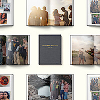 Photo books open to pages showing groups of friends celebrating outdoors, laughing, and standing near water, centered around a closed book titled OUTER BANKS 2020-2024 on a light background.