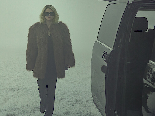 Jessi (Selena Gomez) wears a fur jacket and walks through the snow.