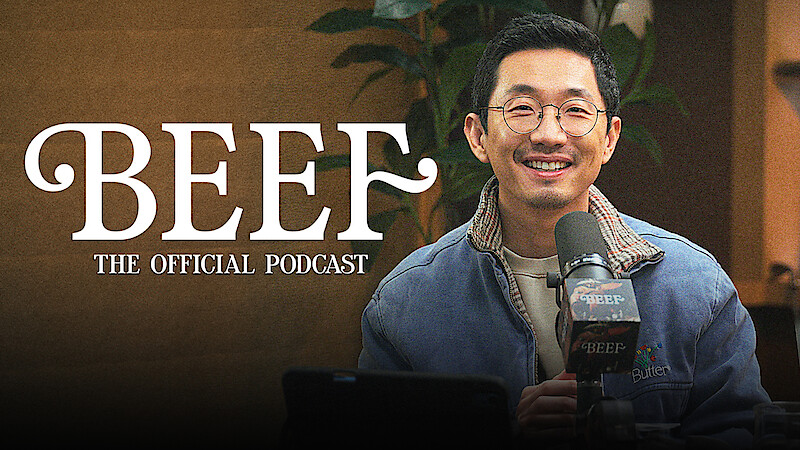 Lee Sung Jin sits at a podcast desk in front of a microphone, with a plant visible in the background. On-screen text reads: “BEEF: The Official Podcast.”