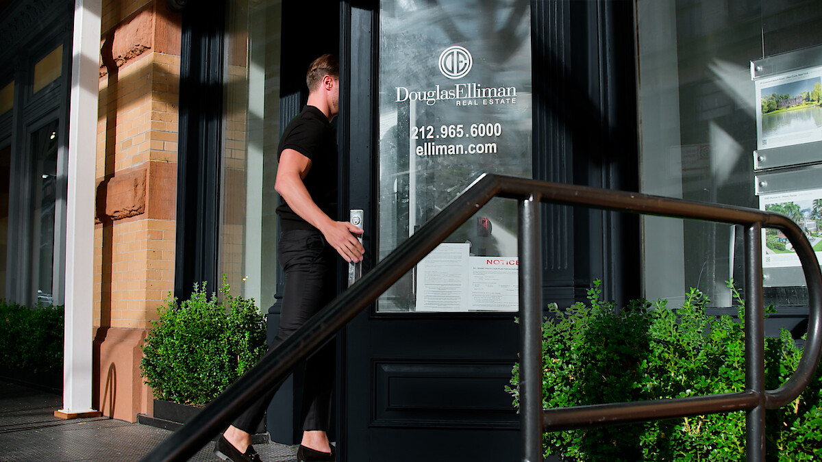 A Douglas Elliman agent enters the building.